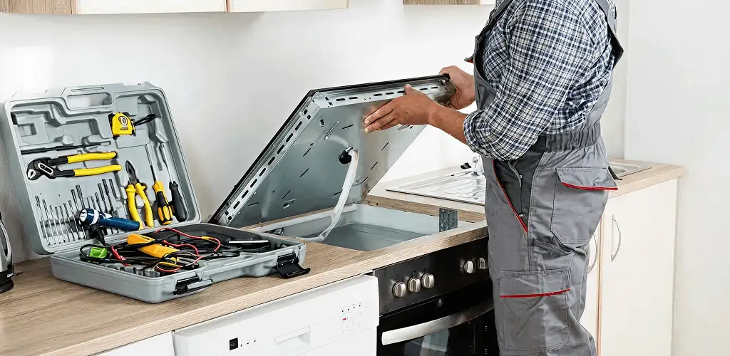 Handyman repairing a cooktop and checking wiring connections in Erie, PA