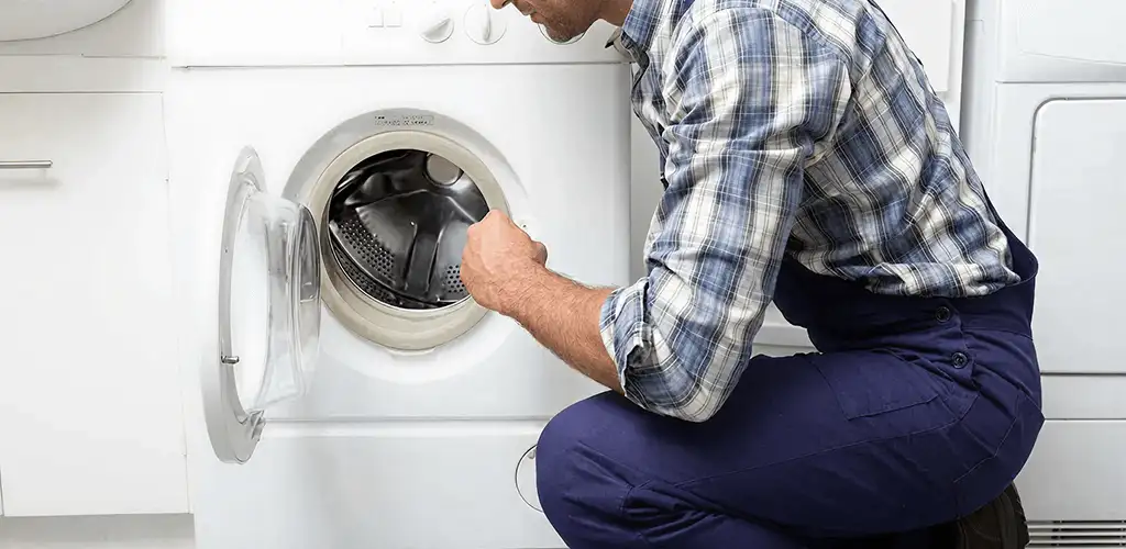Handyman inspecting a dryer drum and internal parts for repair in Erie, PA