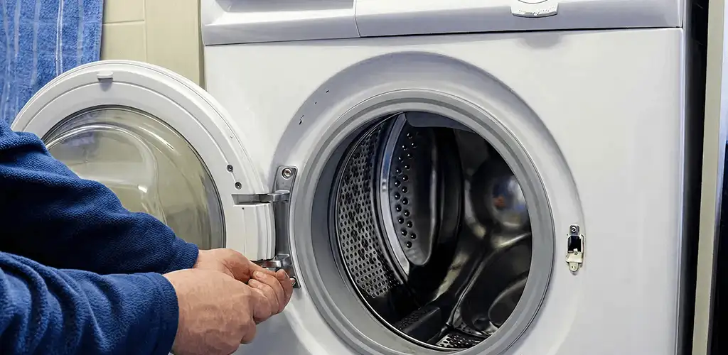 Washing machine repair handyman checking a front-load washer door and latch in Erie, PA