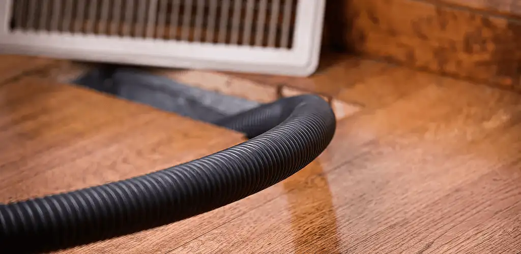 Air duct cleaning hose inserted into a floor vent for ductwork cleaning in Erie, PA